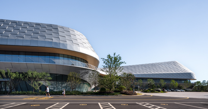scale-like facade wraps hushan swimming center’s undulating form by LYCS architecture