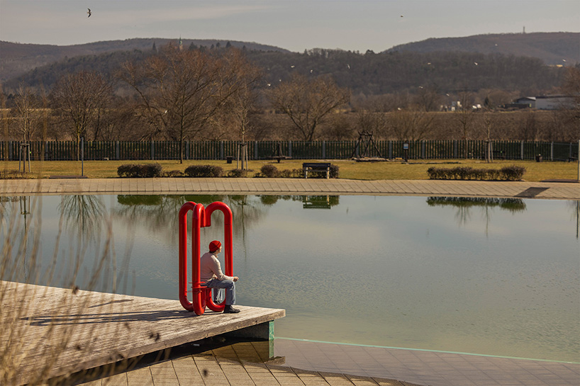 three-legged installation turns industrial gas pipes into intimate public shelter
